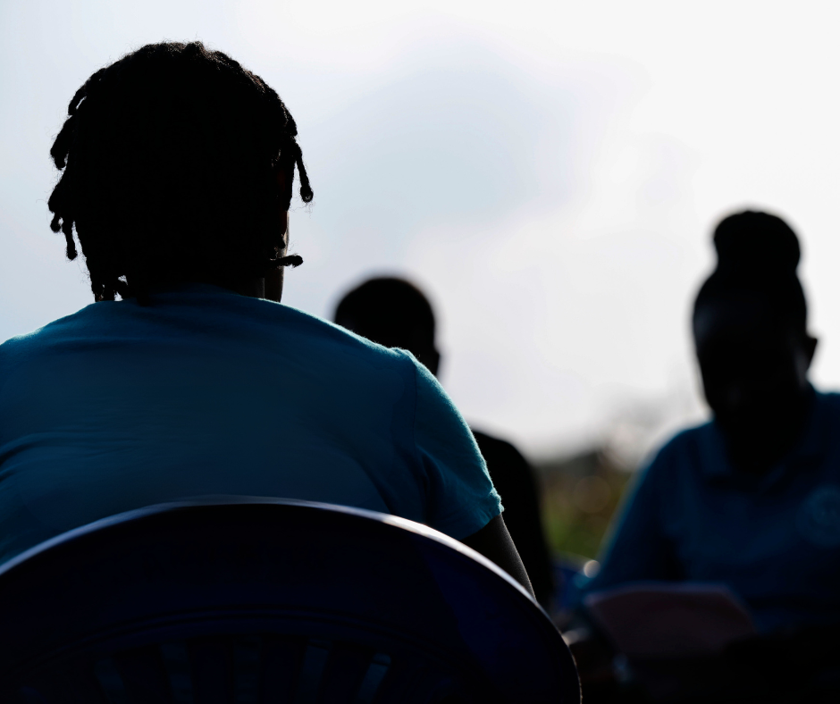 Silouhette of three women from behind wearing blue tshirts.