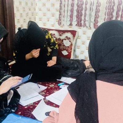A group of Afghan women sit on the floor